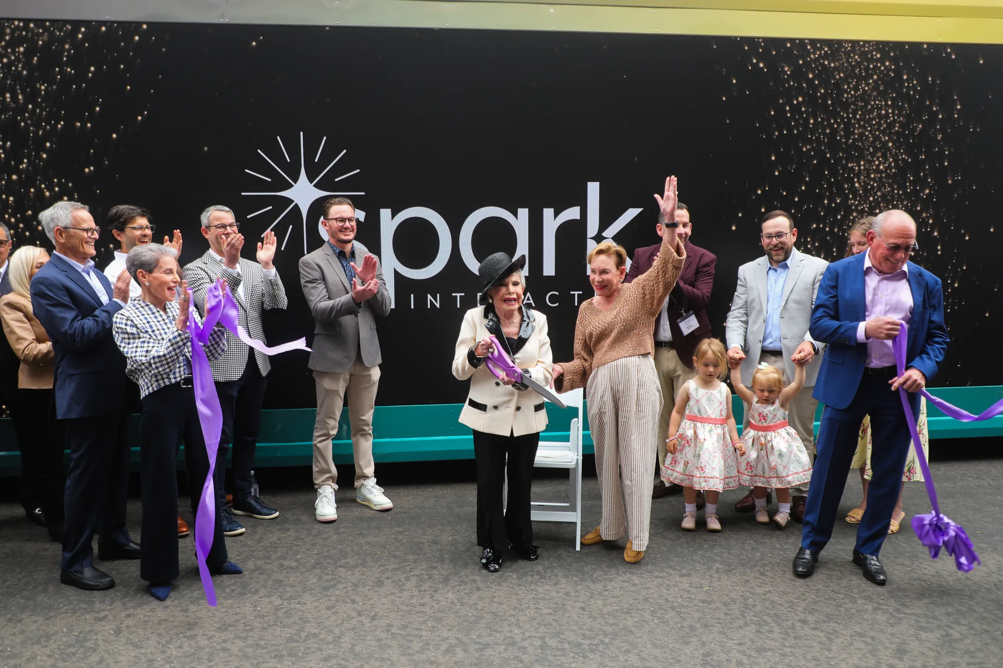 Supporters cheer as the ribbon is cut in front of Spark Interactive at its public launch