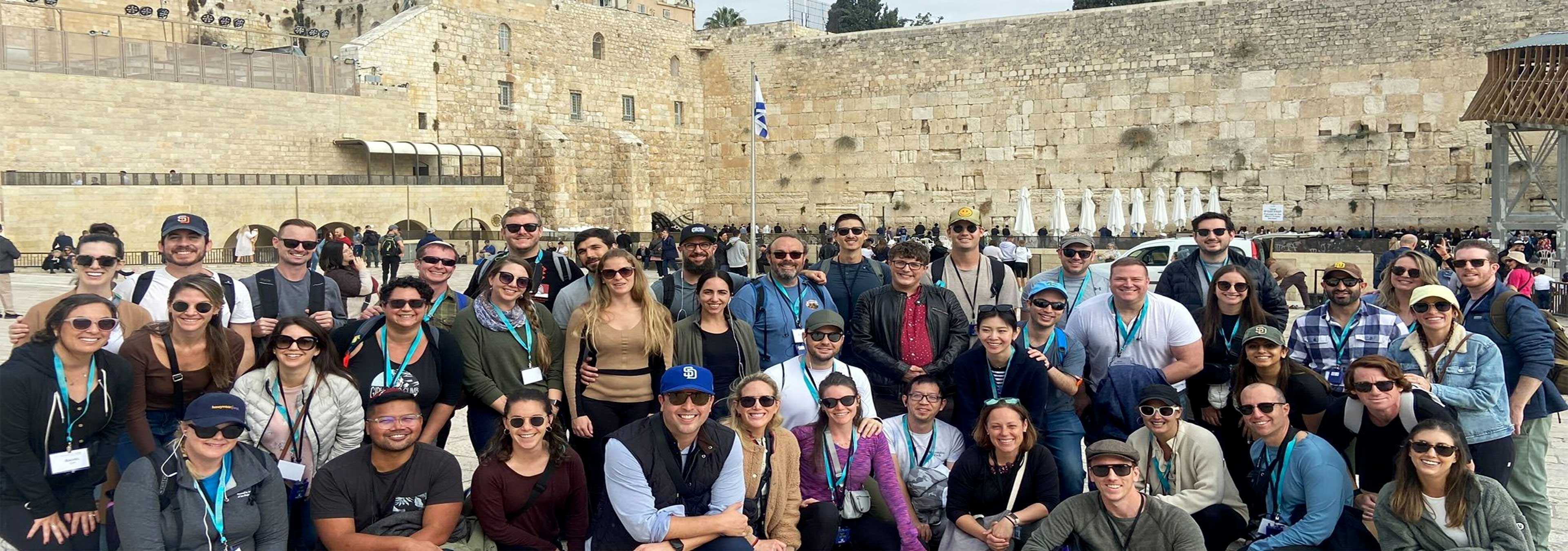 A large group of young adults on a Federation trip, gathered at the Western Wall in Jerusalem