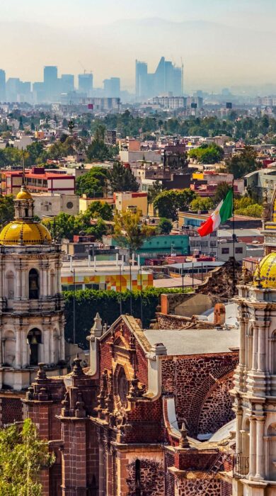 Mexico City's cathedral and bell tower, the Mexican flag, and the downtown skyline