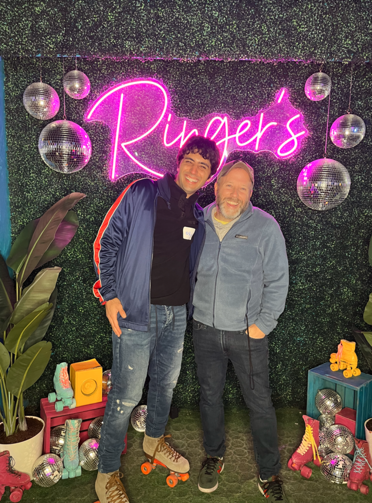 Men standing in front of neon sign