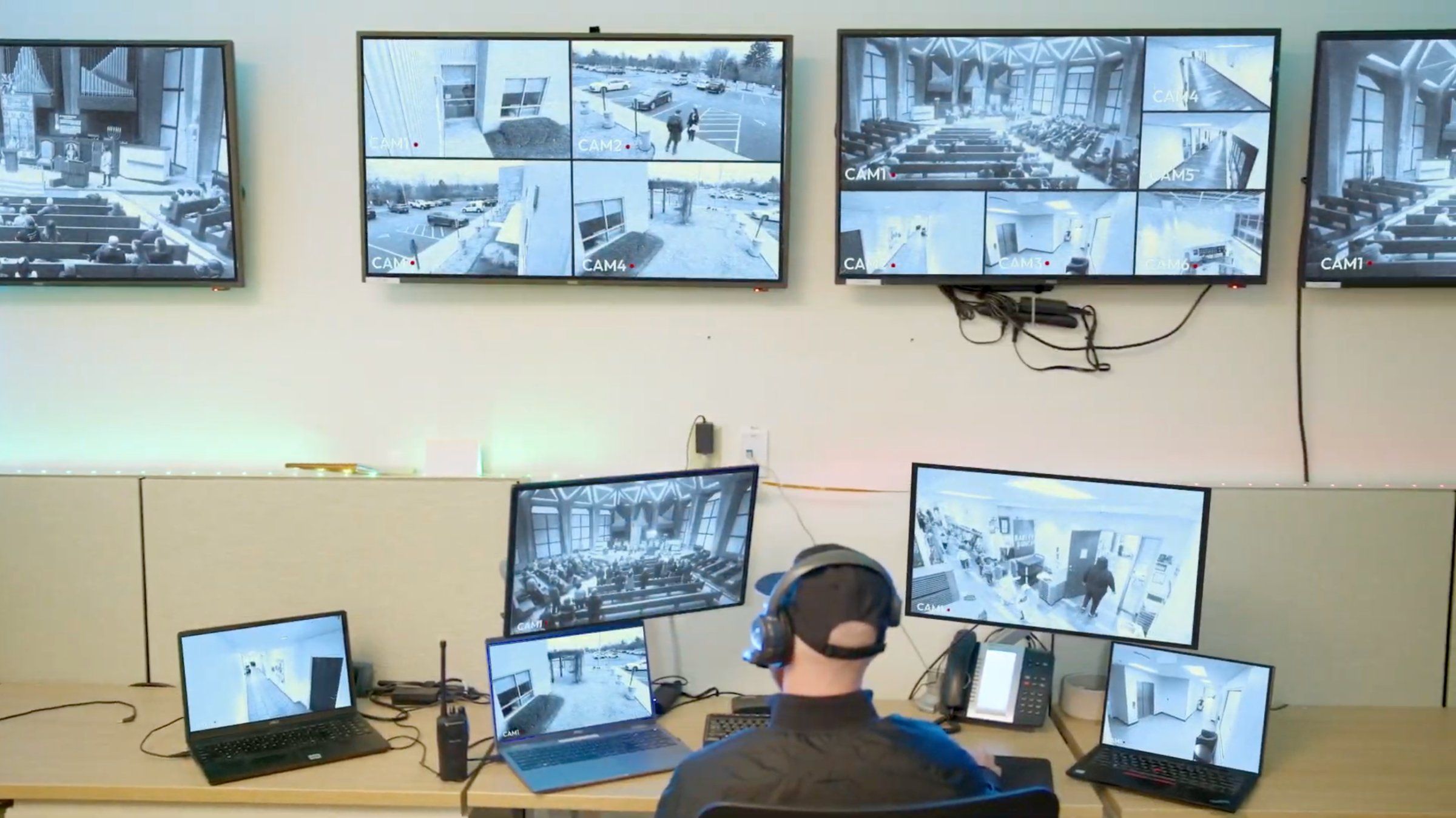 A security room with a wall of monitors watching over community spaces