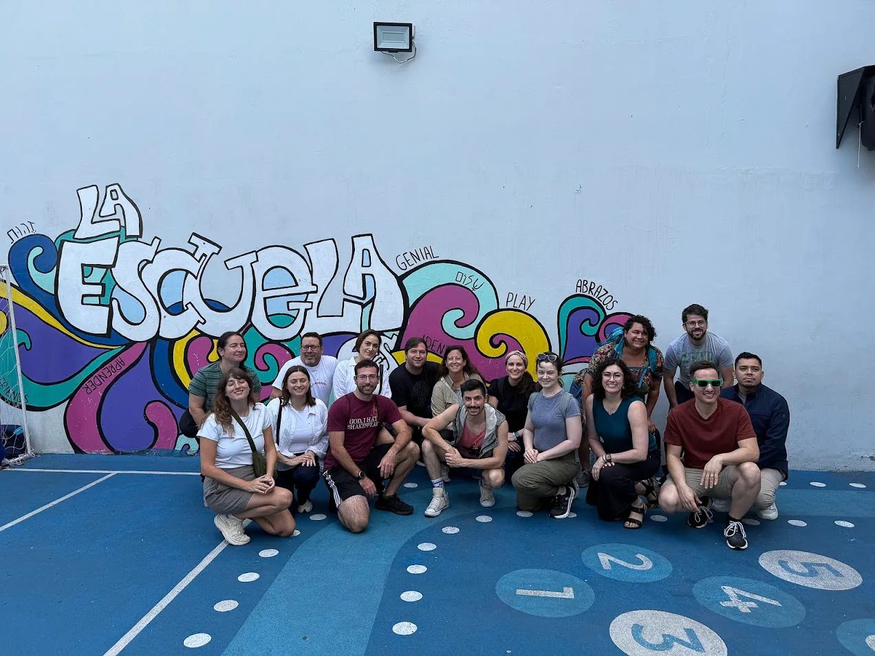 Young adults on the Entwine trip in front of a school mural in Argentina
