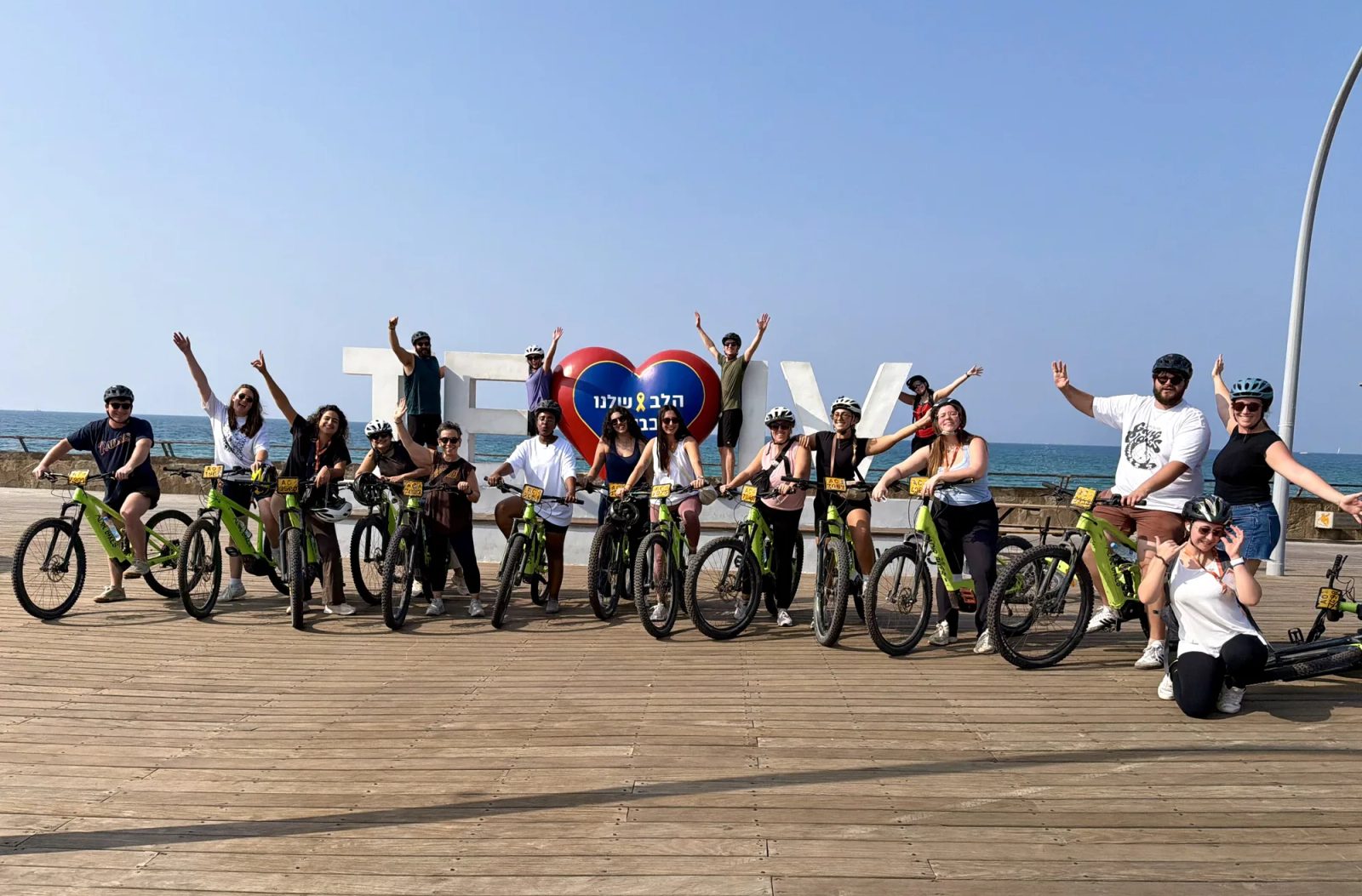 Giborim emerging leaders cheering with their bikes on the Tel Aviv boardwalk
