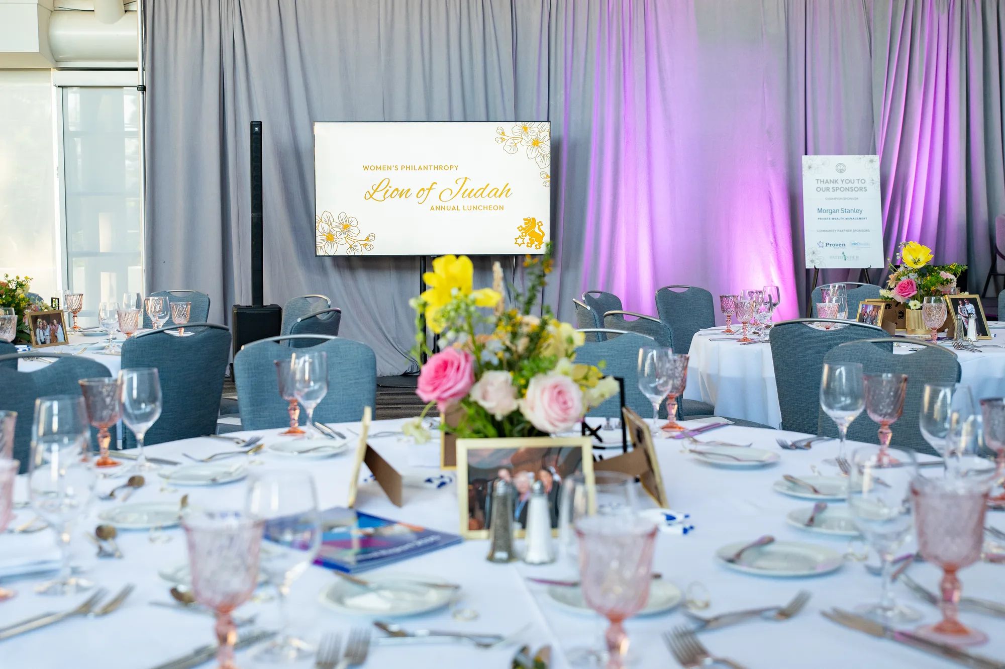 Tables set with flowers beneath the Lion of Judah sign at the 2026 Lion of Judah Luncheon