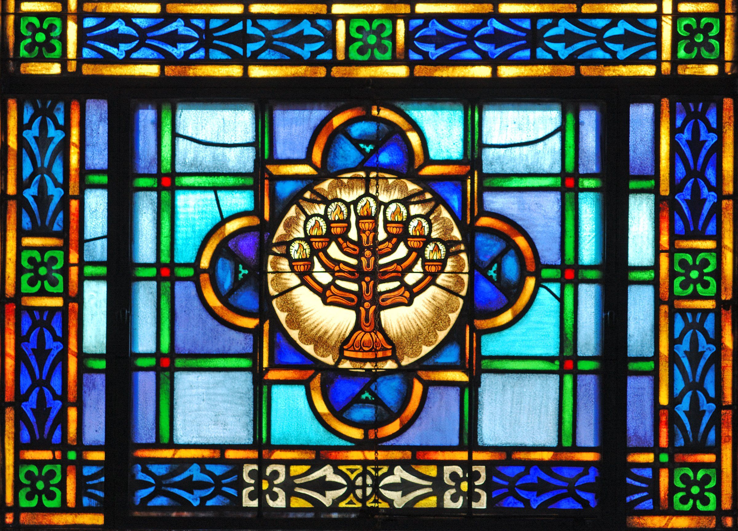 Stained-glass window with a lit menorah at its center